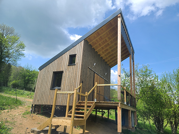 Habitation de loisir ossature bois toiture terrasse. Bardage bois prégrisé. Situé à Chastreix.
